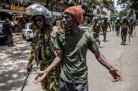 A Kenyan police officer arrests a protester following clashes with opposition supporters in Nairobi,