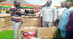 A beneficiary (left) receiving his items from the MCE