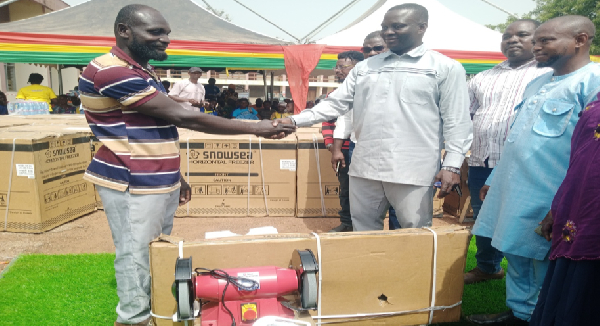 A beneficiary (left) receiving his items from the MCE