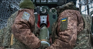 Ukrainian servicemen of the 48th separate artillery brigade load an artillery shell before