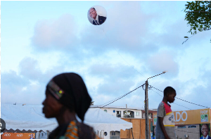A balloon bearing the image of President Alassane Ouattara floats above supporters during a campaign