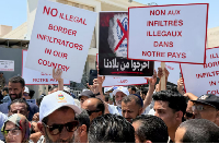 Libyans demonstrate in front of the UNHCR office in Tripoli