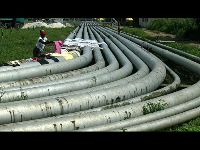 Woman dries clothes on an oil pipeline in Port Harcourt