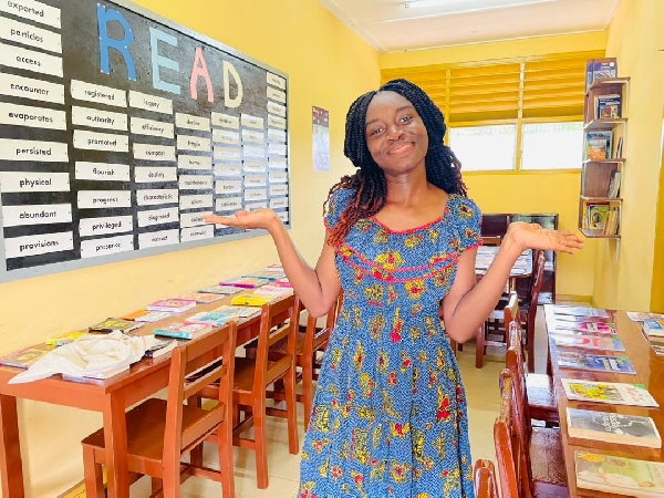 An elated Trudy standing inside the mini library after the place was opened
