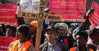 A pastor holds a wooden cross during an anti-xenophobia march in Johannesburg
