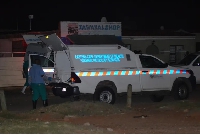 Members of the Forensic Pathology Services stand at the scene of a mass shooting in Gqeberha, SA.
