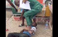 The suspect (on the floor) being stamped by the CID officer