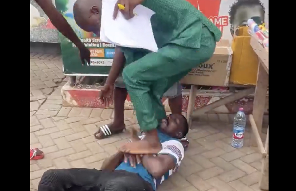 The suspect (on the floor) being stamped by the CID officer
