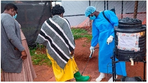 People disinfecting shoes in Mubende, Uganda