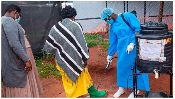 People disinfecting shoes in Mubende, Uganda