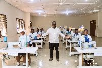 Francis Asenso-Boakye with some students behind the industrial machines