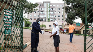 A woman sanitises her hands in front of Kibuli Muslim Hospital in Kampala, Uganda