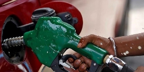 A pump attendant pumps fuel into a car at a fuel station