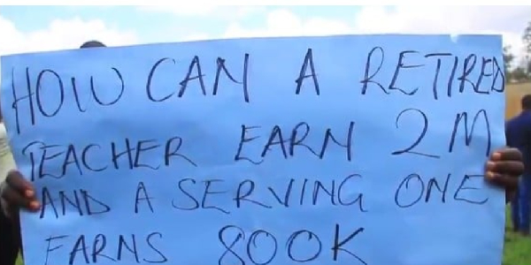 One of the humanities teachers holds a protest poster during their meeting in Masaka City