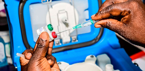A Kenyan health worker measures the dosage of a malaria vaccine in Ndhiwa, Homabay County