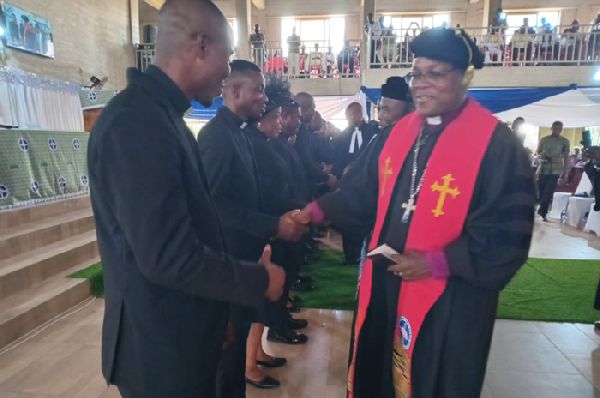 Rt. Rev. Dr. Lt. Col. (Rtd.) Bliss Divine Agbeko in a handshake with the newly inducted pastors