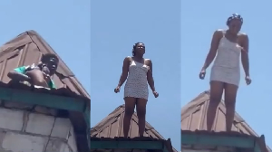 Young Nigerian woman stands on roof of uncompleted building in apparent suicide attempt