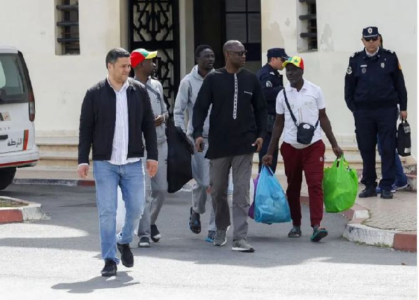 Senegal football supporters walk with their personal belongings after being released from Al Arjat 2