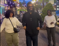 Kofi Adoma being cheered on by his wife and a relative during a walk