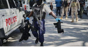 A police officer carries equipment seized from suspected kidnapper's car