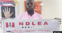 A file photo of Afolabi  Kazeem Micheal holds up a NDLEA sign with his name and age