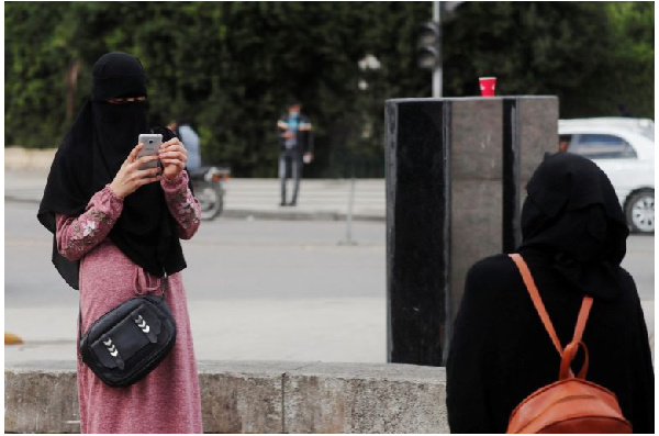 An Egyptian woman wearing a niqab takes pictures in Cairo