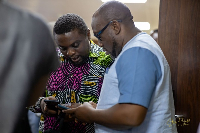 A fie photo of two men trying to navigate their phone