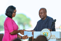 President Mahama (R) handing out the cheques to the clubs