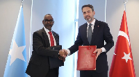 Abdirisaaq Omar Mohamed (L) shakes hands with Turkish Energy Minister Alparslan Bayraktar