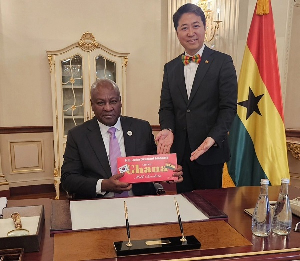 Kojo Choi in a pose with President Mahama while delivering the branded chocolate