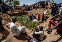 People prepare bodies for burial [Sani Maikatanga/AP Photo]