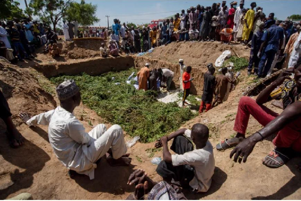 People prepare bodies for burial [Sani Maikatanga/AP Photo]