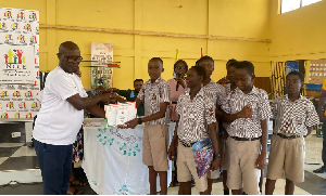 The NCCE Director presenting the contestants with a copy of the 1992 constitution