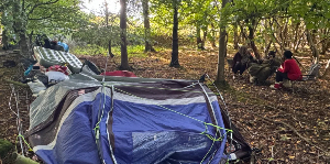 The group previously camped left of the wire fence and have now moved a few metres to the right