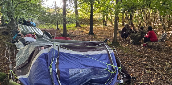 The group previously camped left of the wire fence and have now moved a few metres to the right
