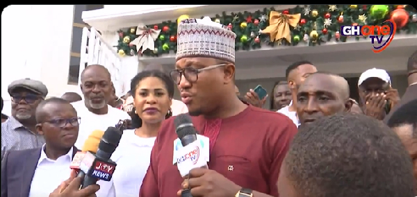 Baba Sadiq, speaking to the media, Ebi Bright (dressed in white standing behind Baba Sadiq)