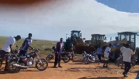 Resident gather near road construction equipment