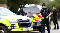 Aerial footage shows wheeled robot near white vans