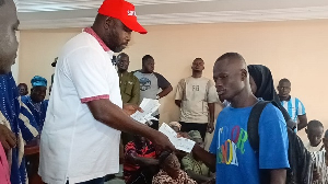 A student (R) receiving a cheque from the MP