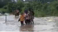 Students are seen walking through flood