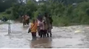 Students are seen walking through flood