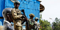 Members of the M23 rebel group stand guard as people attend a rally addressed by Corneille Nangaa