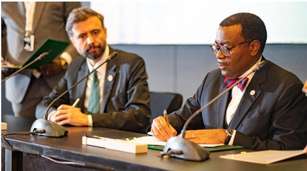 AfDB President Akinwumi Adesina (right) signs a document