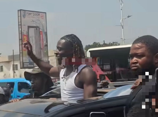 Jeremy Doku waving to some fans as he arrived in Madina