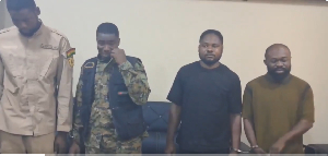 Reagan Amponsah Asare (L) visibly moved to tears while police officers took their mugshots