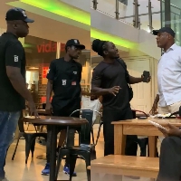 The middle-aged man in white (left) in an altercation with Ghanaian waiter