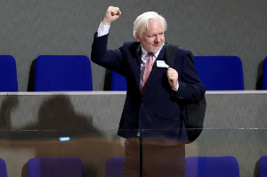 WikiLeaks founder Julian Assange raises his fist after a debate on his detention and conviction