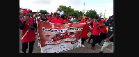 Some protestors clad in red attire and carrying a banner