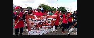 Some protestors clad in red attire and carrying a banner