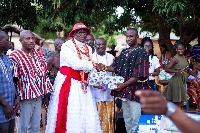 Olu of Warri rep Chief Dr. Eng Olley Wilson Edun presenting items to flood victims